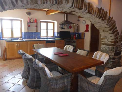 Maison de Xatart heeft een grote keuken waar je eet aan de grote tafel onder de oude stenen bogen